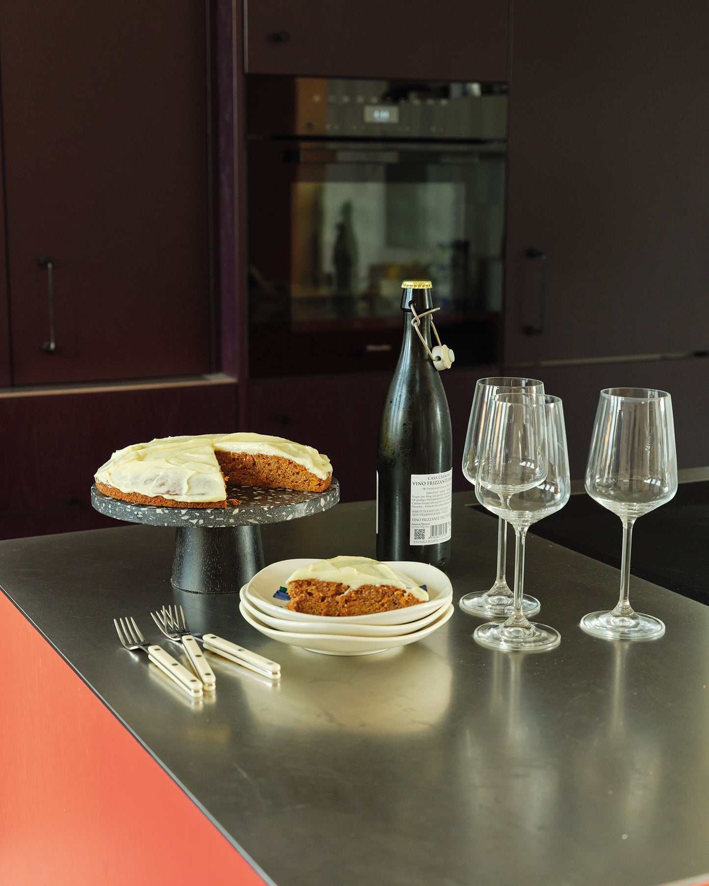 Kitchen counter with carrot cake, wine bottle, and glasses